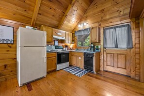 A wooden cabin kitchen with a refrigerator, oven, dishwasher, and wooden cabinets. - Private Studio Log Cabin  Hot Tub Fireplace Relax (Sevierville)