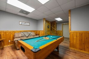 A pool table in a room with wooden paneling, a couch, and a sign that reads "Father." - Nice View  Log Cabin Fireplace Hot Tub Pool Table (Sevierville)