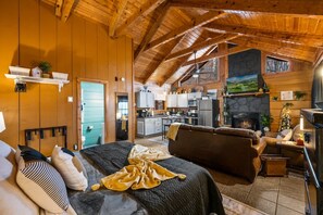 A cozy log cabin interior with a living room, kitchen, and fireplace. - Location-Quiet-HotTub-Fireplace (Pigeon Forge)