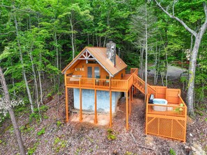 A wooden cabin with a balcony, surrounded by dense forest. - Hot Tub  Cute Studio Cabin  Views  Private  Relax (Sevierville)