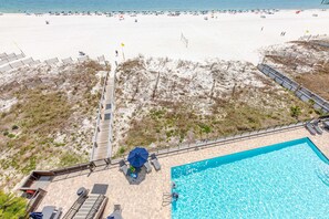 Ein Strandhotel mit Swimmingpool, Strandstühlen und Liegen.