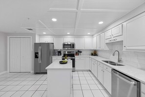 A modern kitchen with white cabinetry, stainless steel appliances, and a central island. - Palms 514- Beachfront condo  2 2  5th floor  BEACH FRONT  sleeps 8 (Orange Beach)