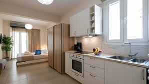A modern kitchen with a built-in oven, a coffee maker, and a fruit bowl on the counter. - Home Easy Kalamata - Central Nest Private Parking (Kalamata)