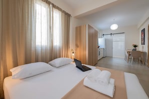 A hotel room with a bed, a laptop, a desk, and a chair. - Home Easy Kalamata - Central Nest Private Parking (Kalamata)