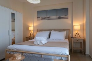 Camera da letto ordinata con un letto, due comodini con lampade, un armadio e un'opera d'arte appesa al muro.