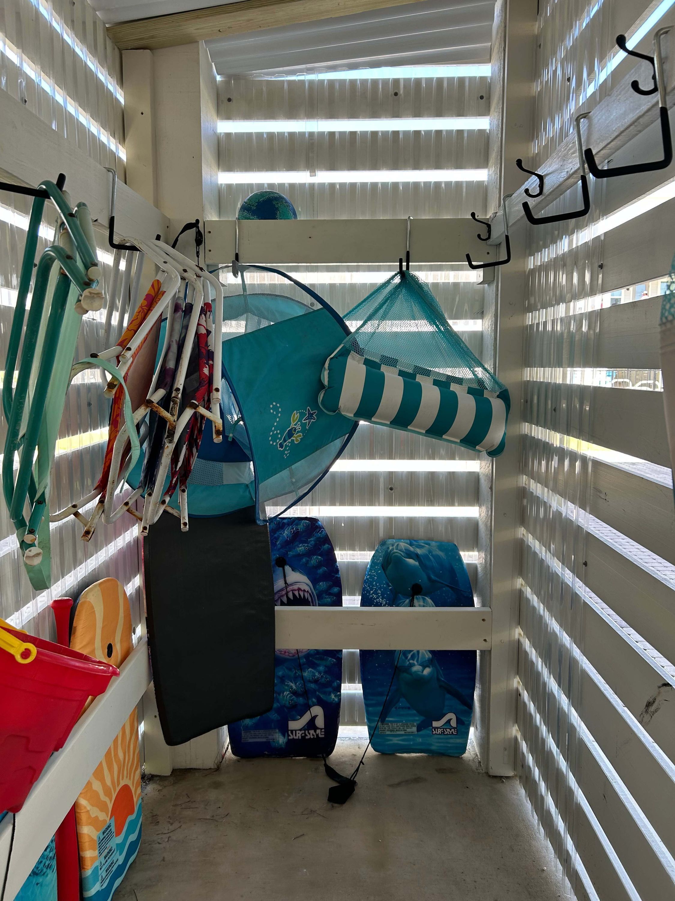 A room with bunk beds, a hanging hammock, and various bags and equipment.