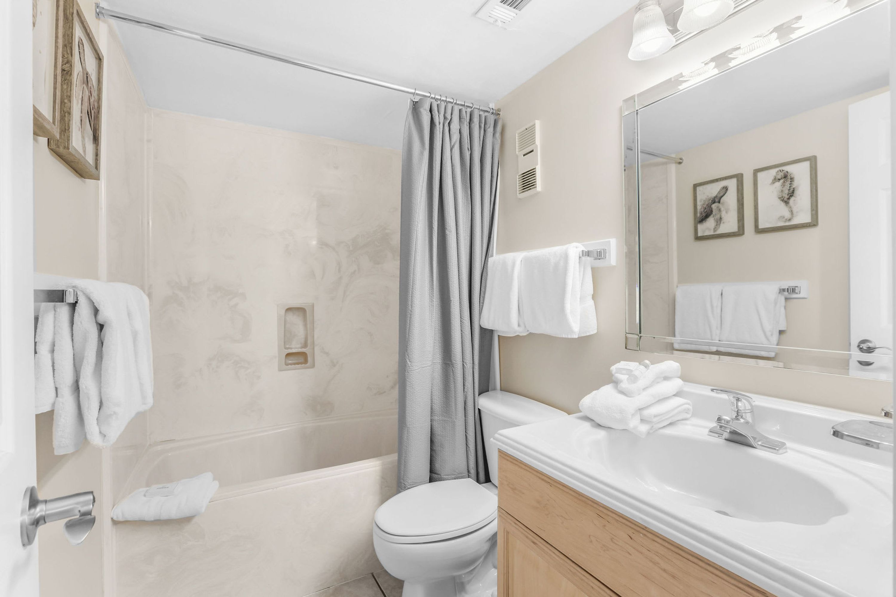 Une salle de bain équipée d’une douche, de toilettes, d’un lavabo et d’un miroir.