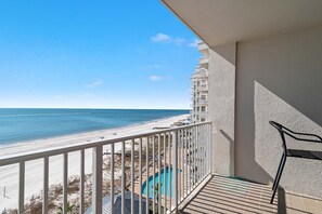 A balcony with a view of a beach and a pool. - Windward Pointe 804- Sleeps 10  beachfront  Resort amenities (Orange Beach)