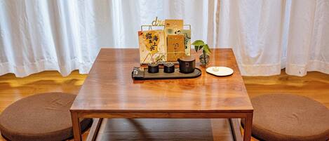 A wooden table with a tray holding a card, a small plant, and a cup.