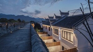 A traditional Chinese courtyard with stone walls, wooden railings, and a tiled roof. - Sanfuyizhai Homestay (Taizhou)