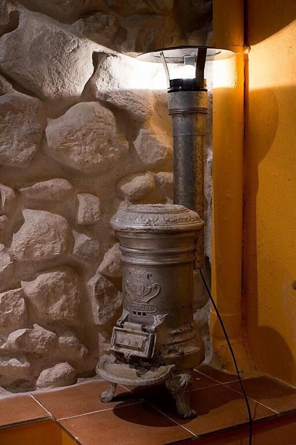 Un mur en pierre, une cheminée et un radiateur fixé au mur.
