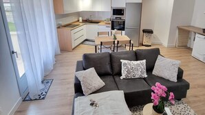 Un salon moderne avec un canapé, une table basse et une vue sur la cuisine.