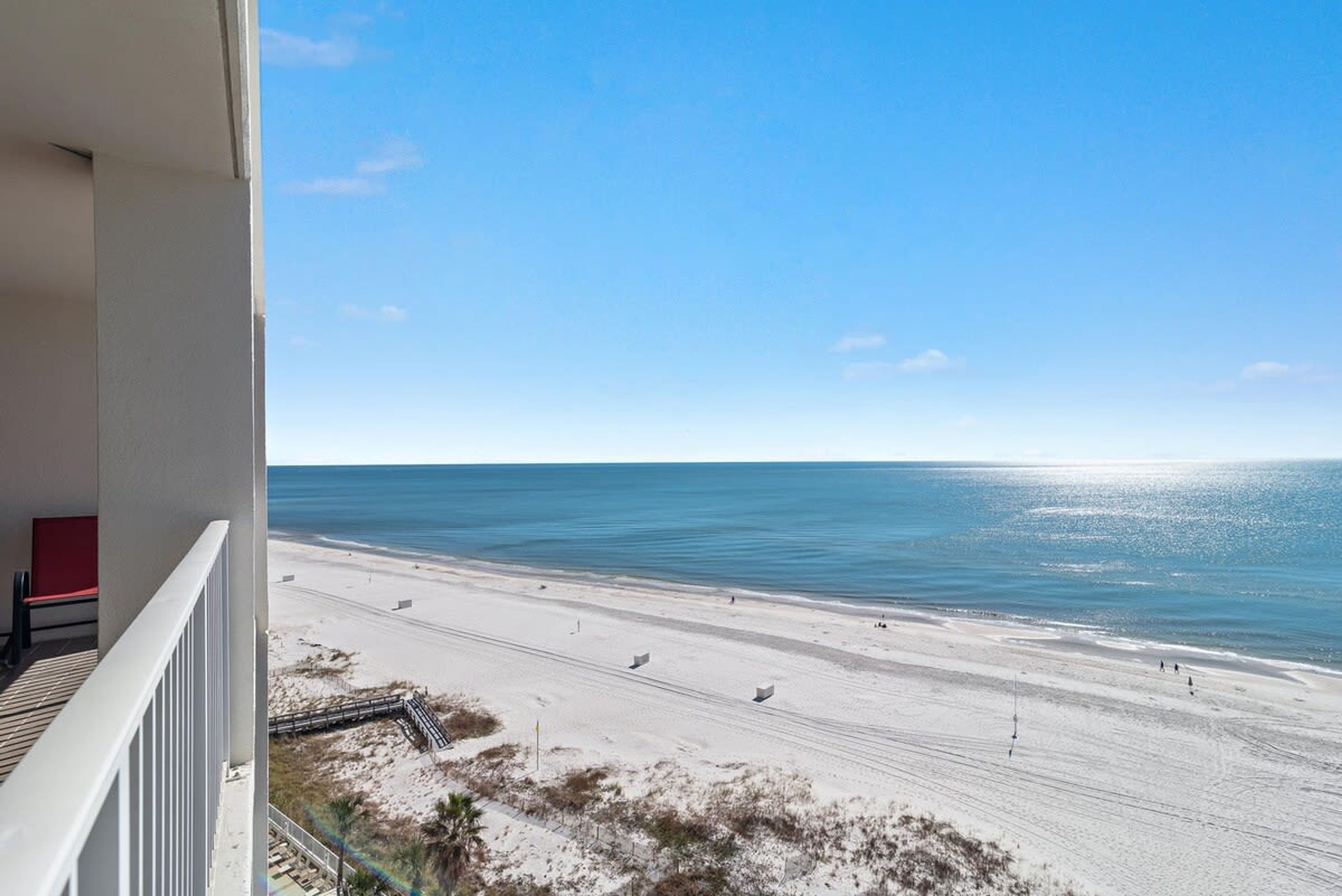 A balcony with a view of a beach and ocean.