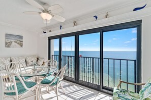 A balcony with a view of the ocean, white wicker furniture, and a ceiling fan. - Gulf Tower 12A- Direct gulf-front  2 2  sleeps 6 (Gulf Shores)