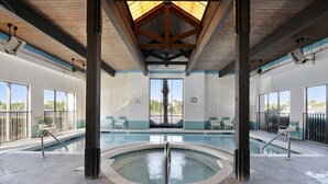 An indoor swimming pool with a wooden ceiling and large windows. - Shoalwater 906  3 3  Gulf-front  CORNER unit (Orange Beach)