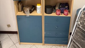 Un espace de rangement doté d’étagères contenant divers objets, notamment des bouteilles, un panier et des récipients.