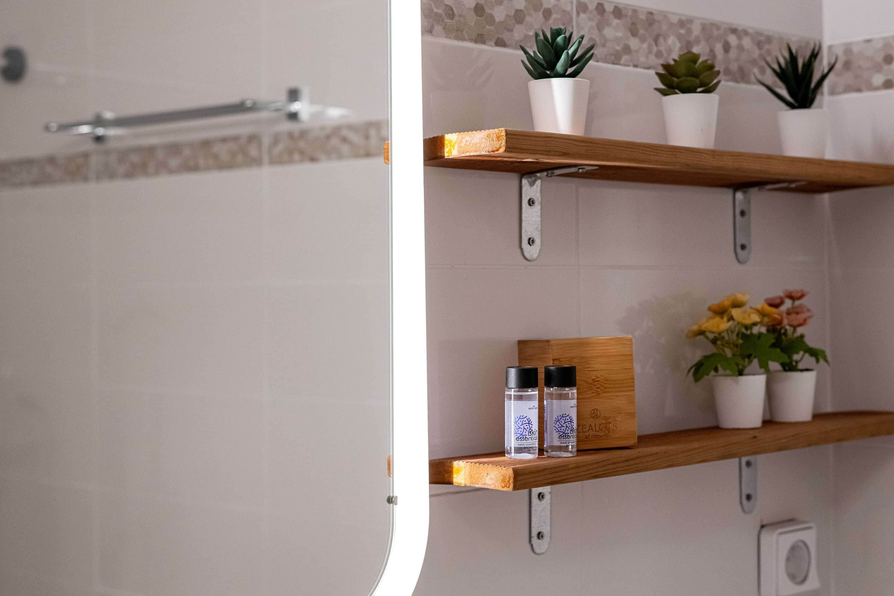 A bathroom with wooden shelves, potted plants, and toiletries.