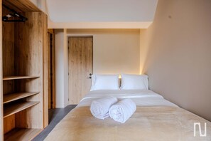 Ein Hotelzimmer mit einem Bett, einem Holzschrank und einer Tür.