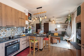 A modern kitchen with wooden cabinets, a central island, and pendant lighting. - Bellissimo Appartamento Vicino al Centro (Sestri Levante)