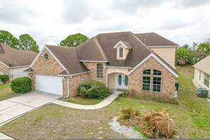A two-story house with a garage, a front porch, and a small front yard with landscaping. - Go!#22 Paddington Way (Kissimmee)