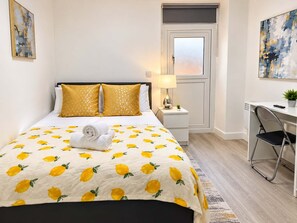 Une chambre d’hôtel avec un lit, un bureau et une chaise.