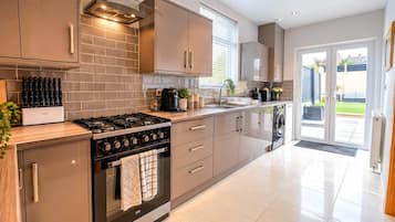 A modern kitchen with a gas stove, oven, and dishwasher, featuring a clean, minimalist design and ample natural light.