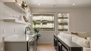 Una cocina moderna con una isla central, estantes empotrados y un amplio ventanal con andamios.