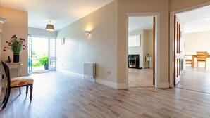 Un vaste espace de vie doté d’un plancher en bois, d’un radiateur et d’un coin repas avec une table et des chaises en bois.