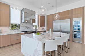 Una cocina moderna con una isla de mármol, electrodomésticos de acero inoxidable y muebles de madera.