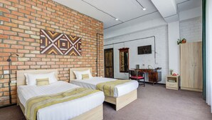 A room with two beds, a brick wall, a wooden desk, and a wardrobe. - Olive Ala-Archa Hotel & SPA (Kashka-Suu)
