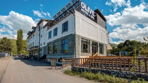 A hotel with a stone facade, multiple windows, and a sign reading 'OLIVE HOTEL & SPA'. - Olive Ala-Archa Hotel & SPA (Kashka-Suu)