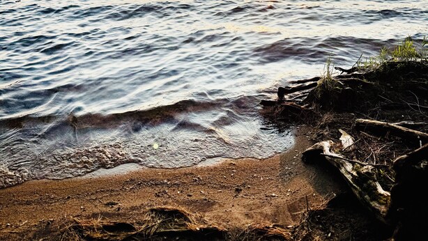 A sunset over a calm lake with a rocky shoreline. - Hoel Pond Hideaway@Saranac Inn (Saranac Lake)