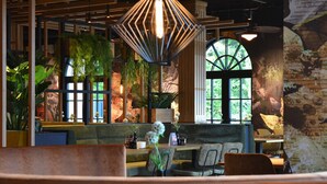 A cozy restaurant interior with wooden beams, large windows, and indoor plants. - Making The Best Memories Along The Way! Free Breakfast and Parking! (Burgh-Haamstede)