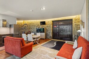A compact living space with a kitchen, dining area, and seating area. - Casa Da Padroa: Private Pool, Wi-Fi & Air Conditioning in Braga (Vila de Prado)