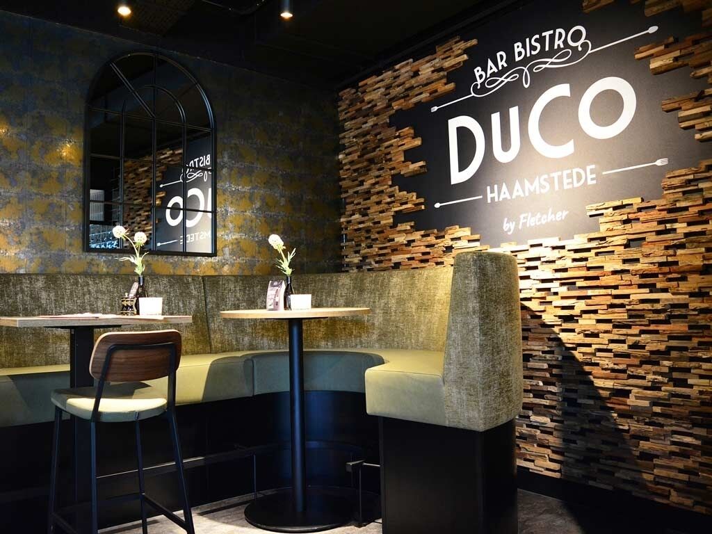 Een bar met een rustieke inrichting, met een houten wand en een bord waarop staat 