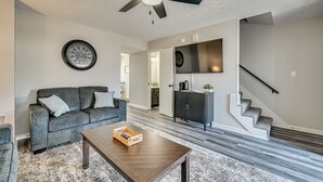 Una sala de estar con sofá, mesa de centro y ventilador de techo.
