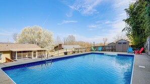 Ein rechteckiger Swimmingpool mit glasklarer, blauer Wasseroberfläche, umgeben von einer Holzterrasse.