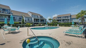 A pool area with lounge chairs and umbrellas, surrounded by a building with balconies. - Pool Access & Near Beach! Golf Colony Resort Condo (Surfside Beach)