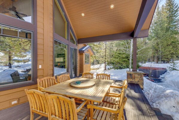 A wooden deck with a table and chairs, surrounded by snow and trees. - Ski-in/ski-out! Mtn-view Donnelly Home w/ Hot Tub (Donnelly)