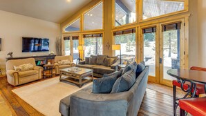 A spacious living room with a large sofa, a coffee table, and a television mounted on the wall. - Ski-in/ski-out! Mtn-view Donnelly Home w/ Hot Tub (Donnelly)