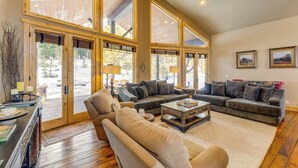 A spacious living room with large windows, a fireplace, and a cozy seating area. - Ski-in/ski-out! Mtn-view Donnelly Home w/ Hot Tub (Donnelly)