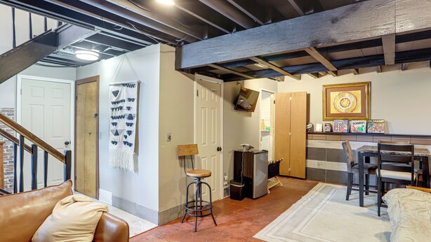 A spacious living area with a brown leather couch, a white rug, and a wooden dining table with chairs. - 6 Mi to Dtwn Toledo! Family-friendly Haven w/ Deck (Toledo)