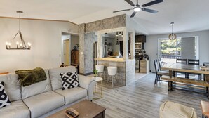A modern living room with a sofa, coffee table, and a dining area with a wooden table and chairs. - 6 Mi to Dtwn Toledo! Family-friendly Haven w/ Deck (Toledo)