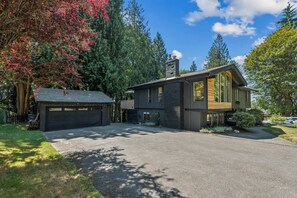 A modern two-story house with a garage, large windows, and a well-maintained lawn. - Modern Forest Escape, Near Lake Stevens & Hikes (Lake Stevens)