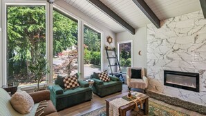 A spacious living room with large windows, a fireplace, and a cozy seating area. - Modern Forest Escape, Near Lake Stevens & Hikes (Lake Stevens)