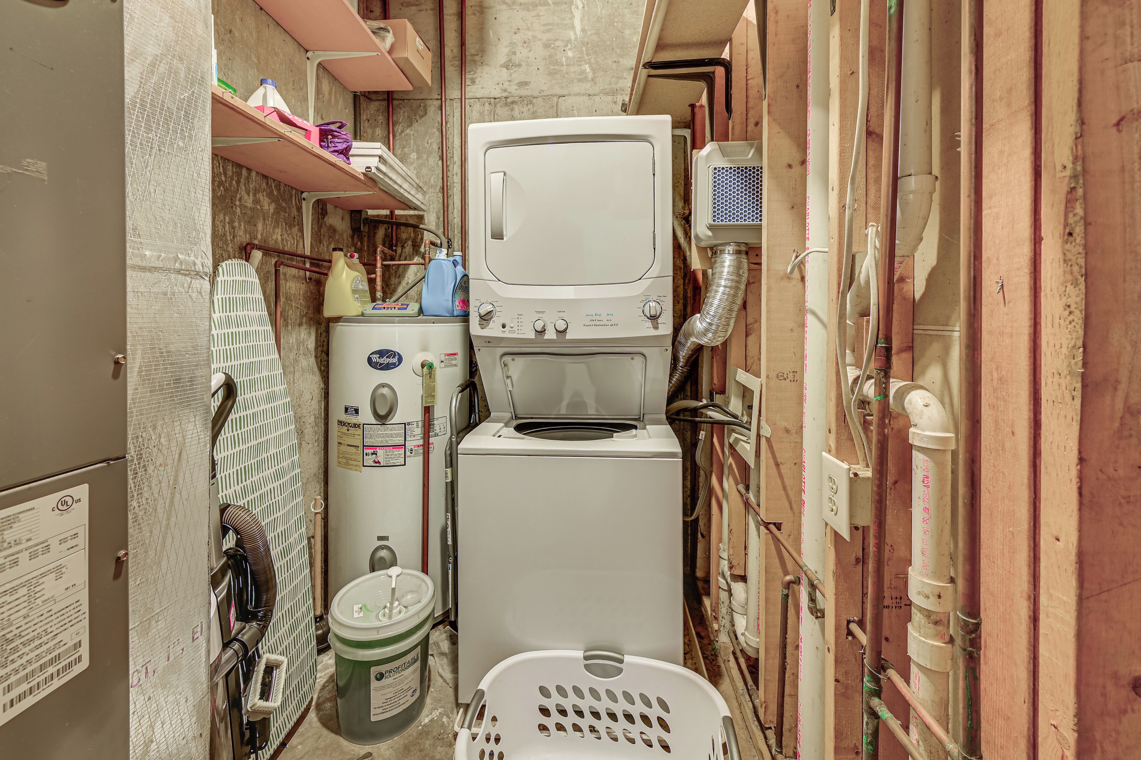 A compact laundry room with a washing machine, dryer, and stacked laundry baskets.