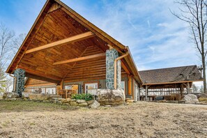 A wooden lodge with a large porch, stone pillars, and a stone fireplace. - Steps to Private Beach! Family Home on Lake James (Morganton)