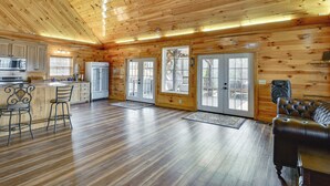 A log cabin interior with a kitchen, dining area, and living room. - Steps to Private Beach! Family Home on Lake James (Morganton)
