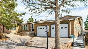 A single-story house with a garage, a front yard with a tree, and a sidewalk leading to the entrance. - Mountain Basecamp Near Red Rocks (Golden)