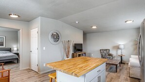 A compact living space with a kitchenette, a dining area, and a bedroom. - Mountain Basecamp Near Red Rocks (Golden)